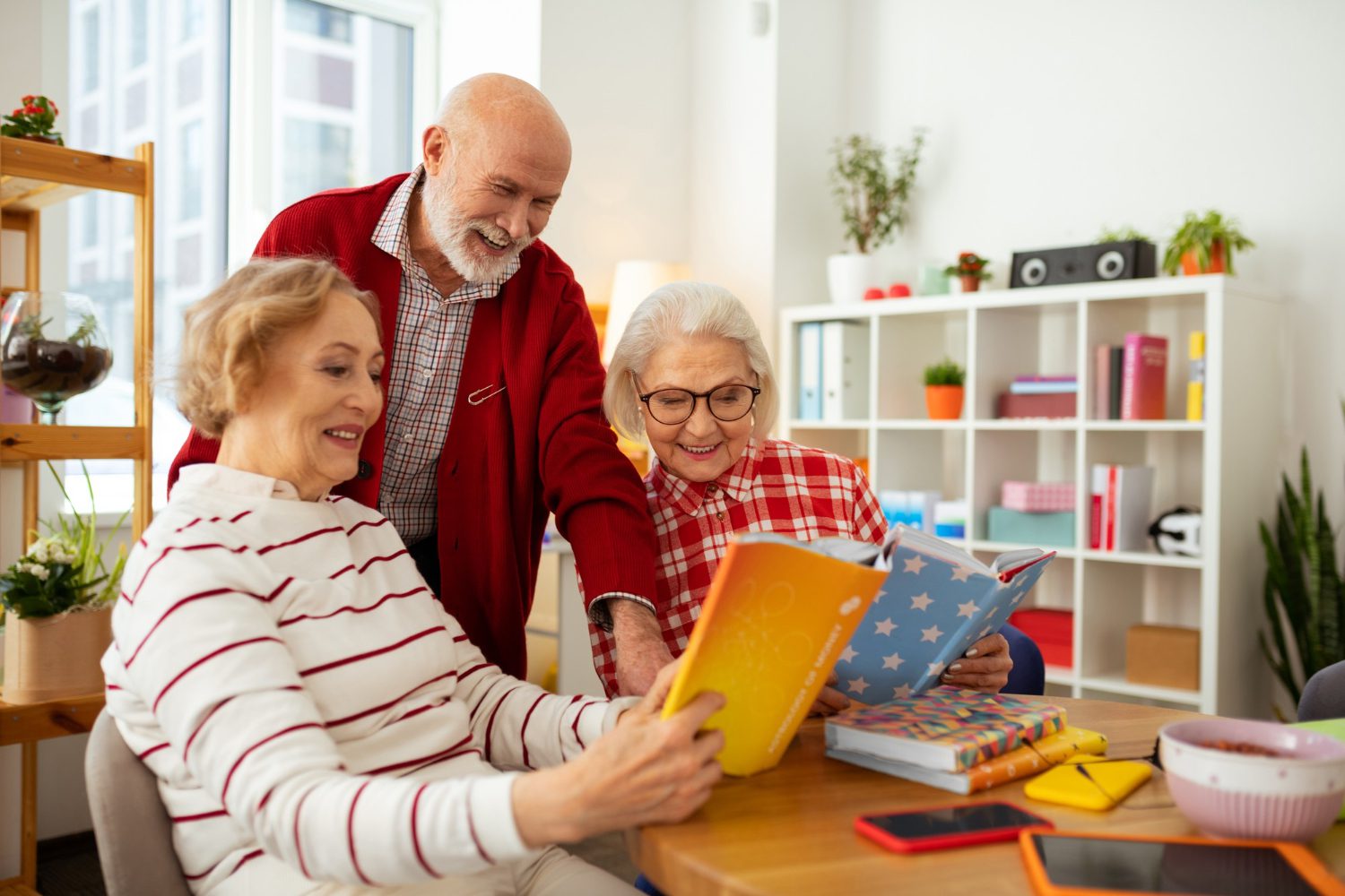 regarde-ici-des-femmes-seniors-joyeuses-souriant-tout-en-montrant-des-livres-à-leur-amie